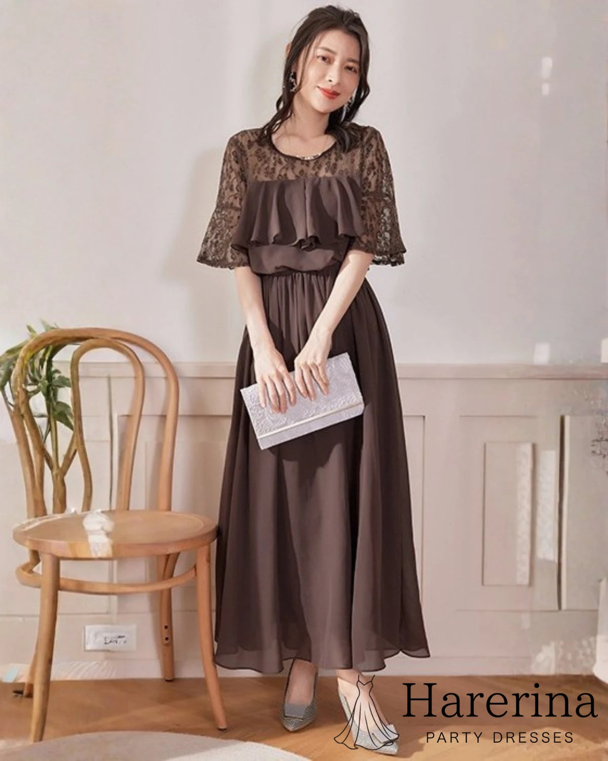 モカブラウンのレーストップ×シフォンロングワンピースを着た女性が、白いクラッチバッグを持って微笑む姿の画像
