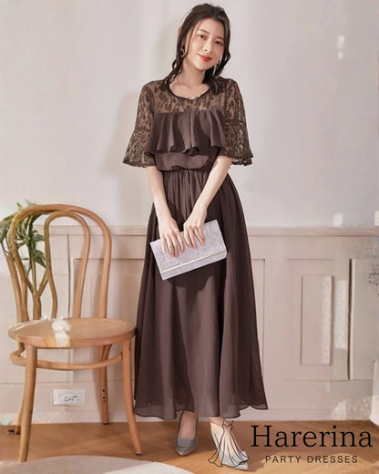 モカブラウンのレーストップ×シフォンロングワンピースを着た女性が、白いクラッチバッグを持って微笑む姿の画像
