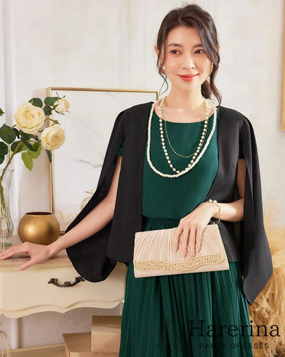 フレアシルエットが美しいシフォンプリーツワンピース（グリーン）に黒の羽織りを合わせ、バッグを持った上半身コーディネート画像
