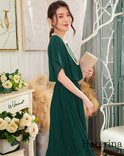 フレアシルエットが美しいシフォンプリーツワンピース（グリーン）、横向きの半身シルエットとバッグを持ったスタイルが分かる画像
