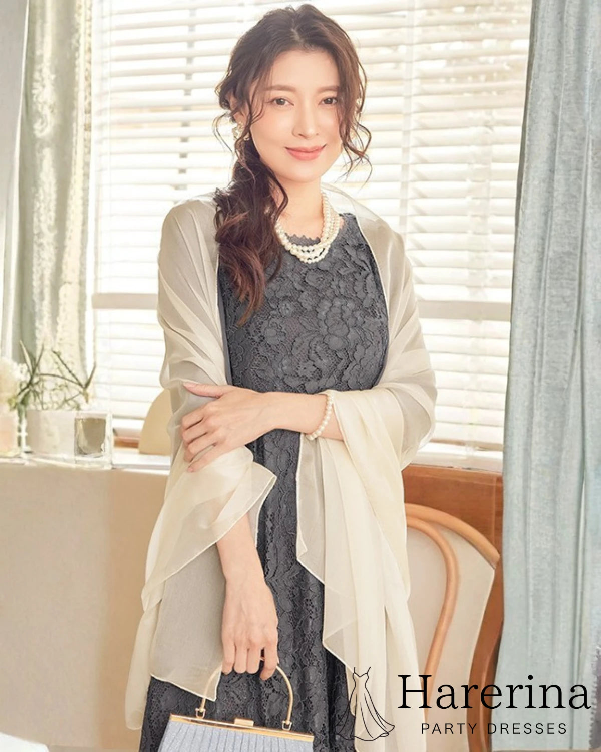 アプリコットの軽やかショールをふんわり肩掛けし、レースドレスと合わせて上品にコーディネートした女性
