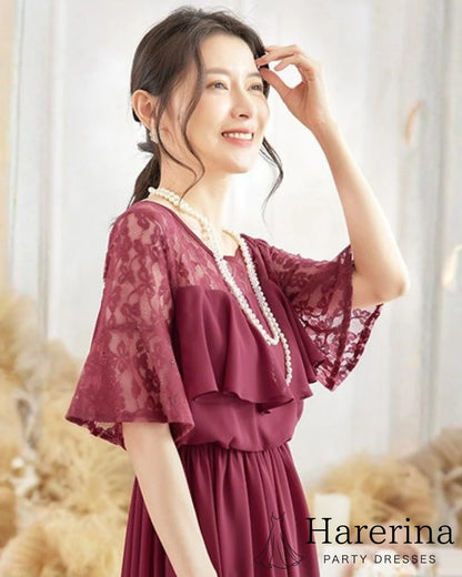 チェリーレッドのレーストップ×シフォンロングワンピースを着た女性が、横向きで微笑む上半身アップショットの画像
