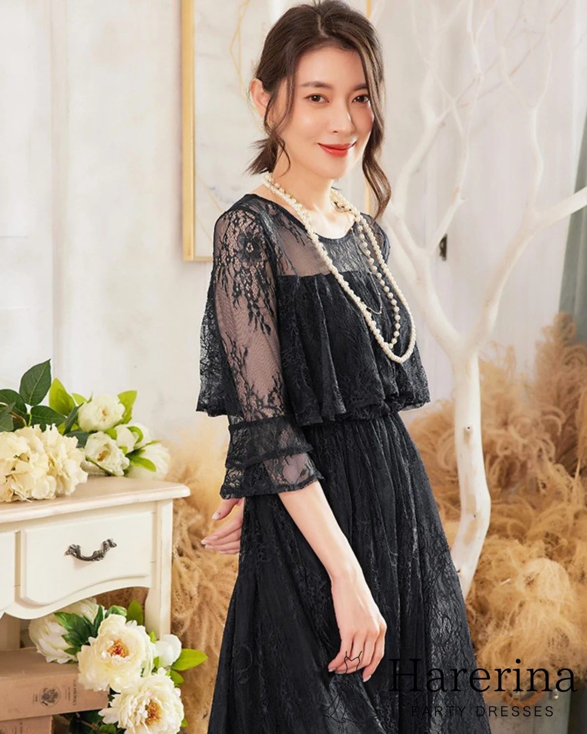 ブラックのレースケープロングドレスを着た女性の上半身アップ写真
