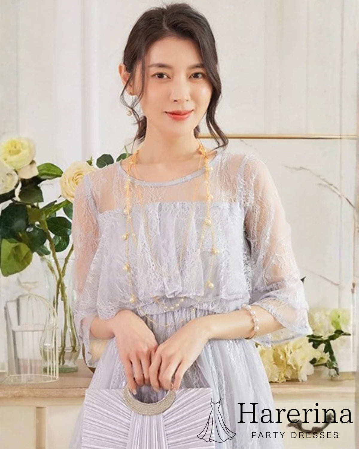 グレーのレースケープロングドレスを着た女性が上品に立っている上半身アップ写真
