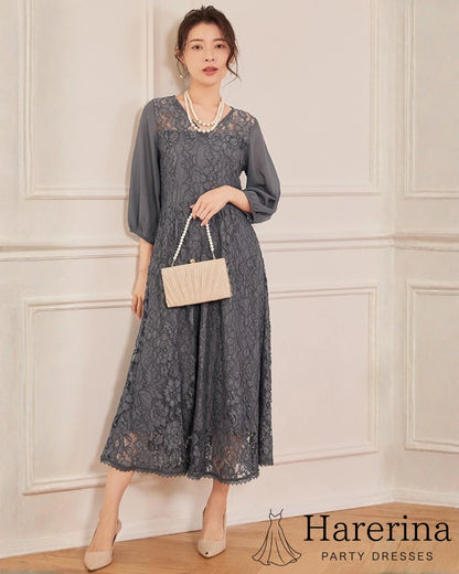 上品レース×シフォン袖ロングワンピースのダークグレーを着用した女性が角度を変えて立つ姿。レースのロング丈シルエットとシフォン袖の落ち着いた質感が引き立つ商品イメージ写真。
