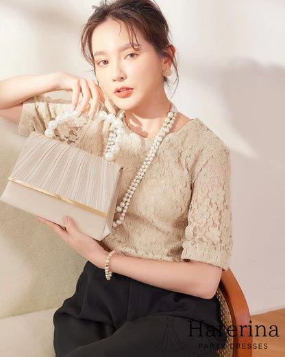 ベージュの華やかプリーツとパール持ち手が魅力のフォーマルクラッチバッグをモデルが手に持って撮影した画像。柔らかい色味と上品な印象が確認できる。
