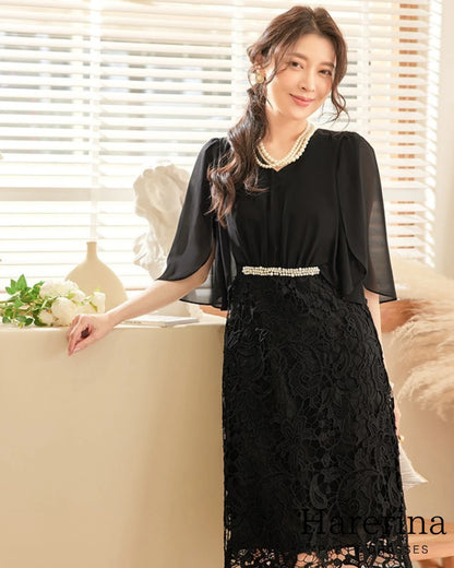 ブラックカラーのパールウエストマーク×膝丈レースドレスを着用した女性を正面から写した画像。シフォン袖とウエストのパール装飾がエレガントな印象
