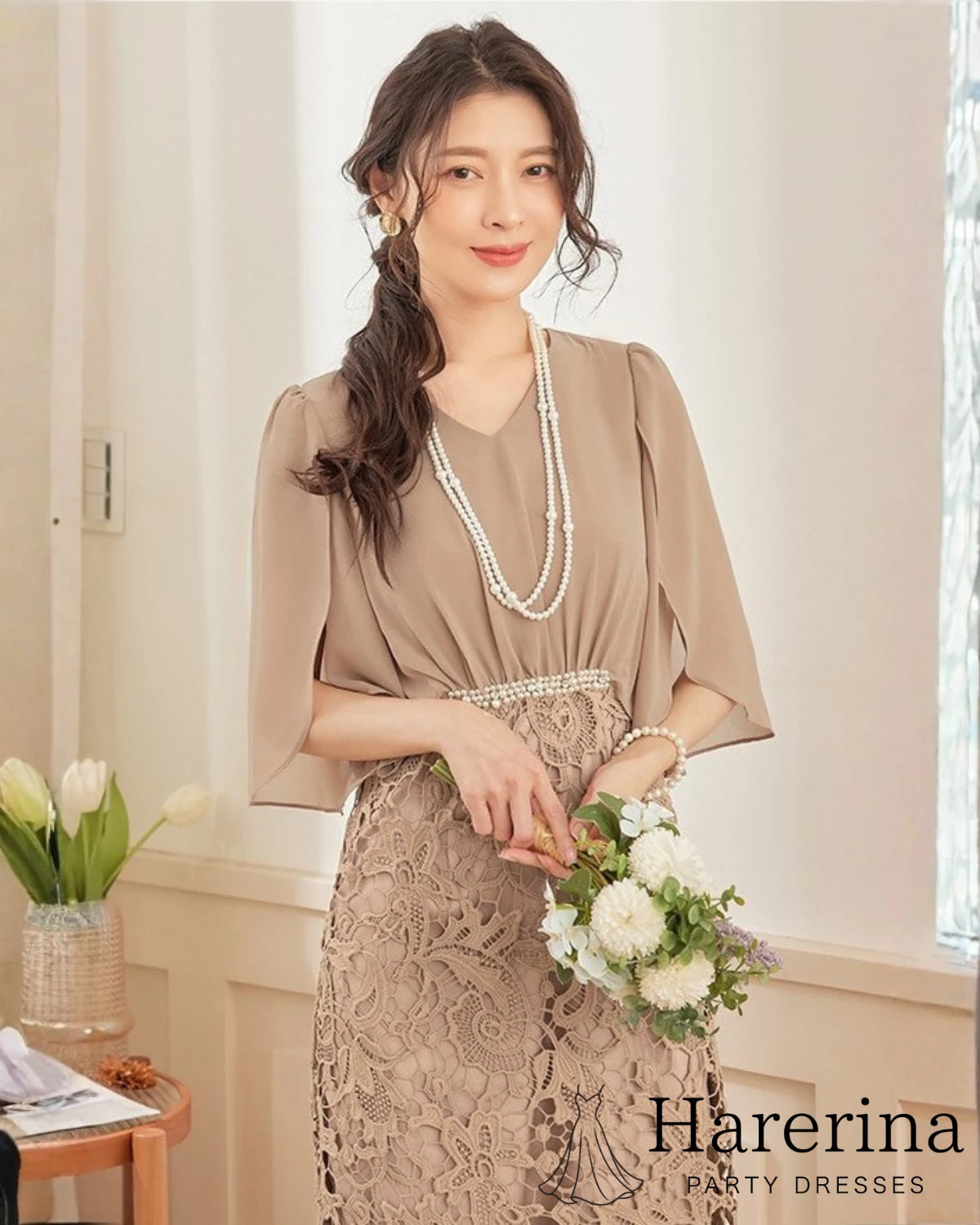 ブラウンカラーのパールウエストマーク×膝丈レースドレスを着用した女性を正面から上半身中心に写した画像。シフォン袖とウエストのパール装飾が上品な印象
