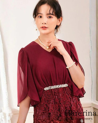 ワインレッドカラーのパールウエストマーク×膝丈レースドレスを着用した女性を正面から写した画像。シフォン袖とウエストのパール装飾が上品なデザイン

