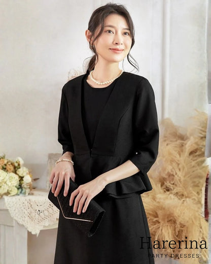 黒のペプラムジャケットとワンピースのセットアップを着た女性を上半身中心に撮影したイメージ写真
