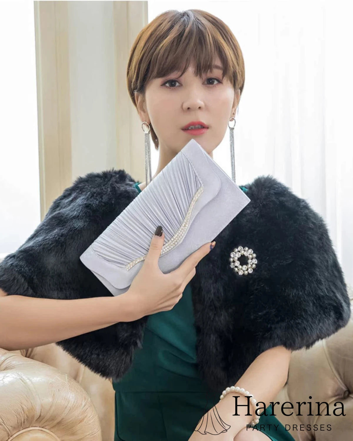 グリーンドレスとファーショールにグレーのプリーツ×ラインストーンクラッチバッグを合わせたコーディネート写真。
