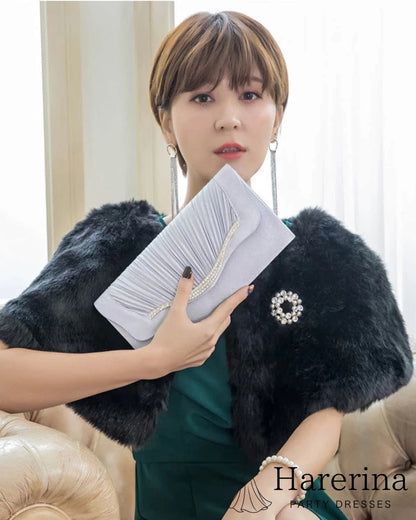 グリーンドレスとファーショールにグレーのプリーツ×ラインストーンクラッチバッグを合わせたコーディネート写真。
